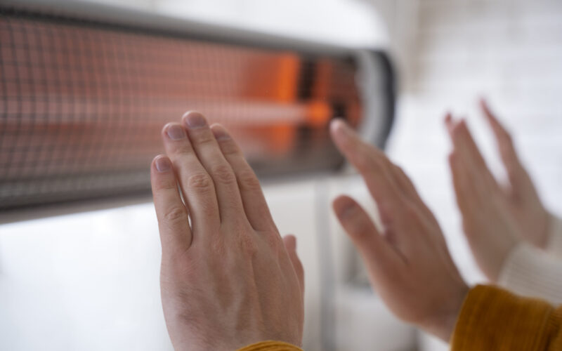 gros-plan-personnes-se-rechauffant-mains-pres-du-radiateur