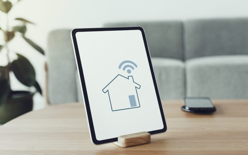 Digital tablet screen with smart home controller on a wooden table